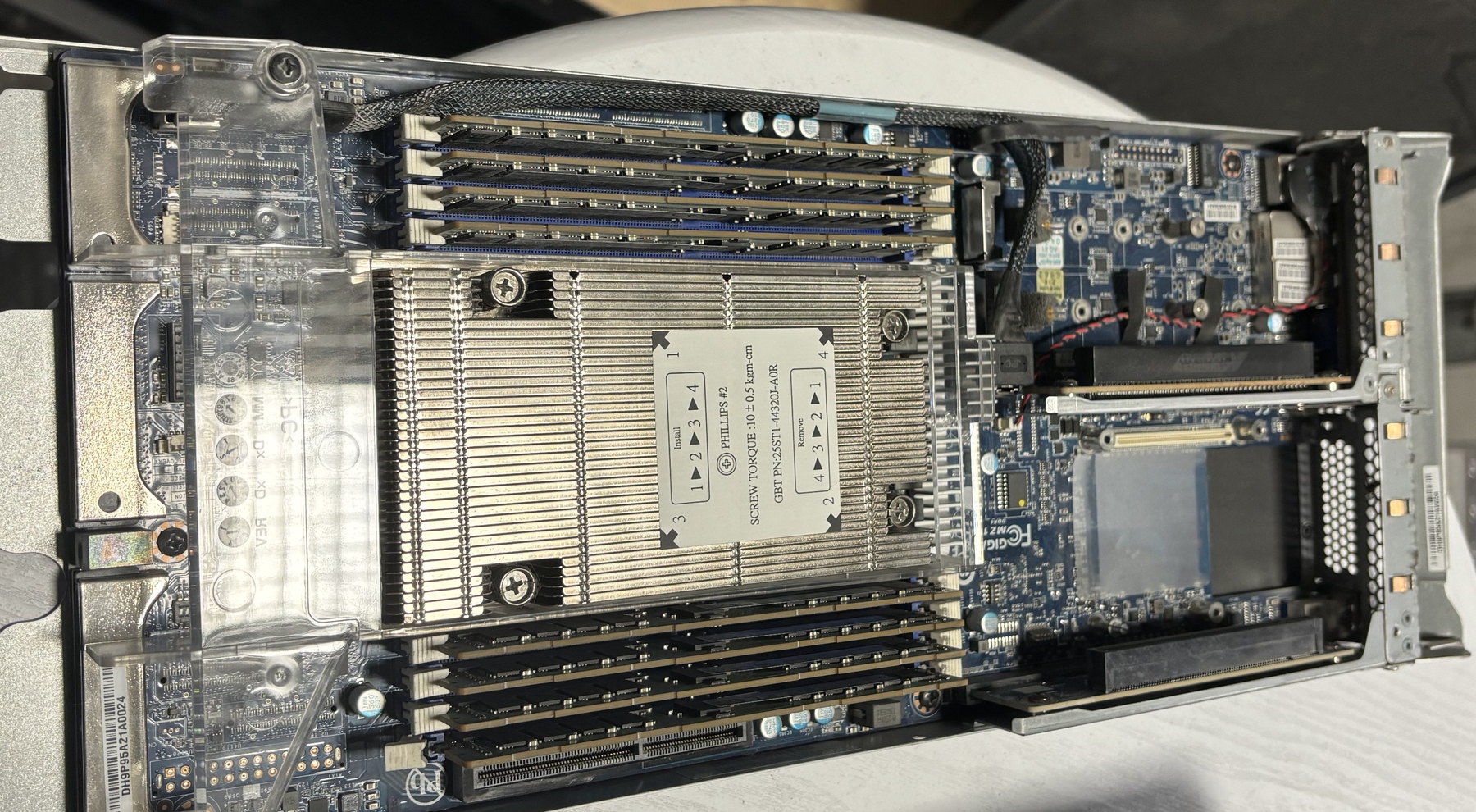 An open server node: the processor heatsink in the centre, two banks of memory modules either side of it.